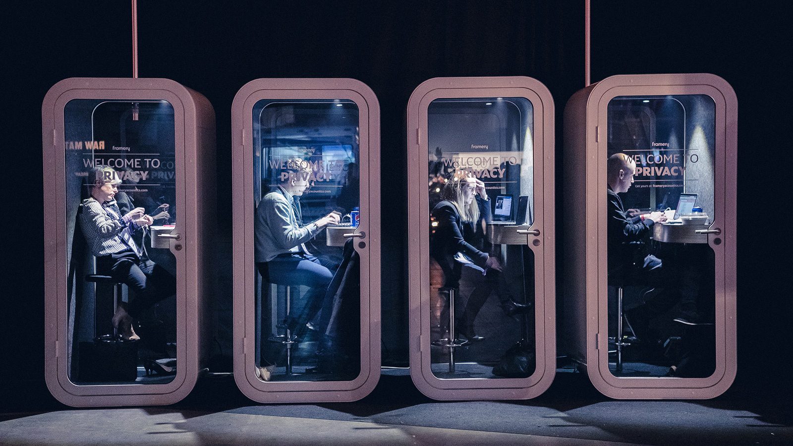 neljä työskentelykoppia vierekkäin, kaikissa yksi työntekijä sisällä